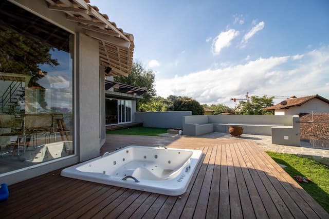 Un spa semi-enterré apporte un style moderne à une terrasse en bois
